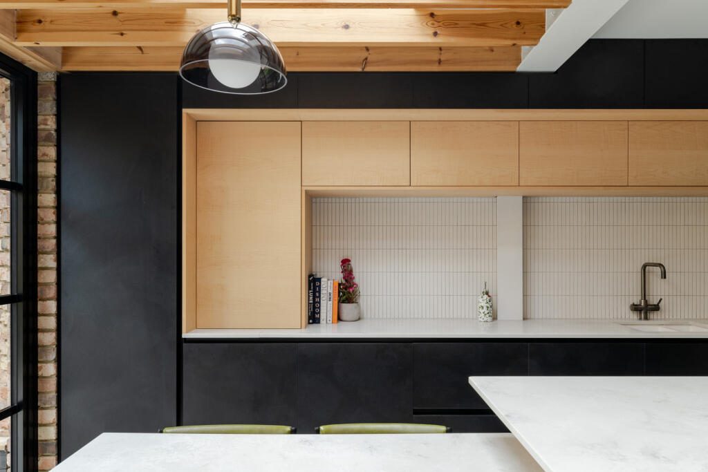 Kitchen with birch ply units, black cabinetry and exposed joists, from an earlier project by Phil and Jen.