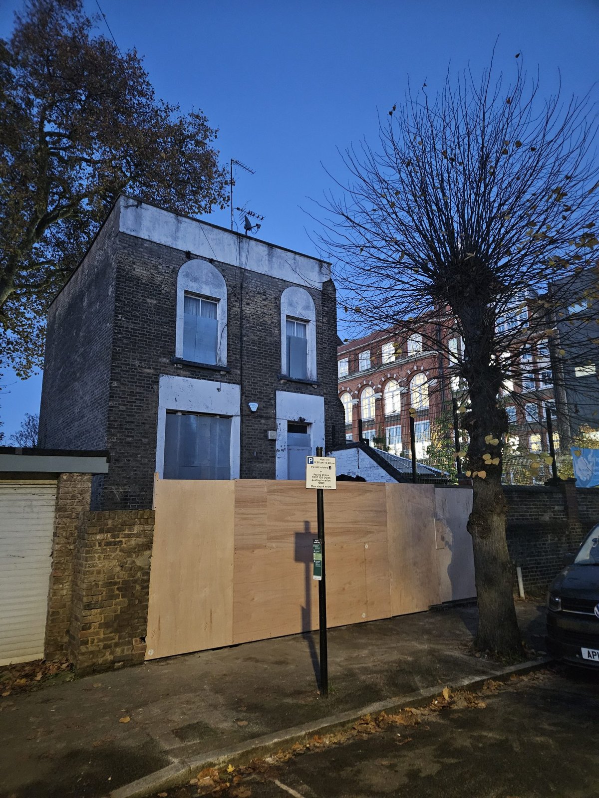 The townhouse in its derelict, boarded-up state before restoration