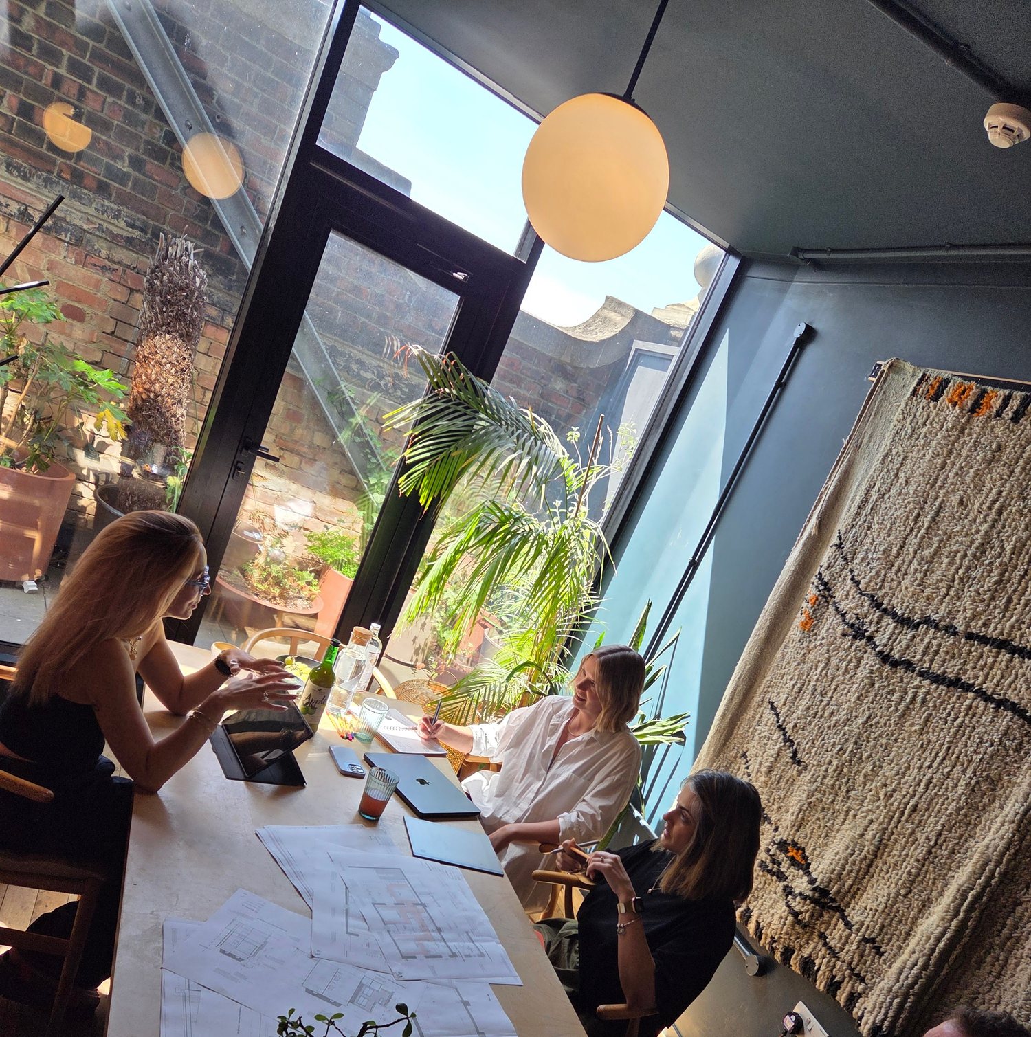 Phil and Jen in a working design meeting with plans on the table